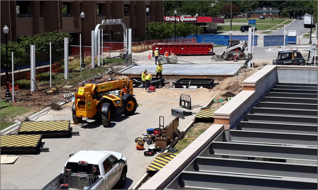Installation of a Delta Scientific vehicle barricade system in progress at an urban construction site, with workers, heavy machinery, and barricade components in view, illustrating Delta's expertise in integrating security solutions in public infrastructure.