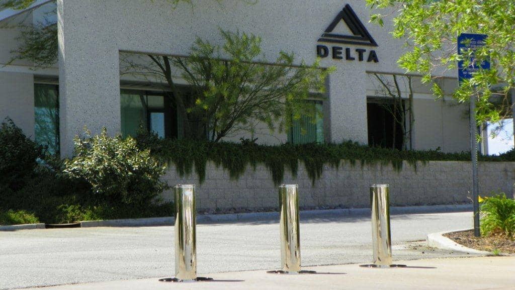 Entrance to Delta Scientific's facility secured with stainless steel retractable bollards, reflecting the company's dedication to perimeter security and controlled access using their own high-strength security solutions.