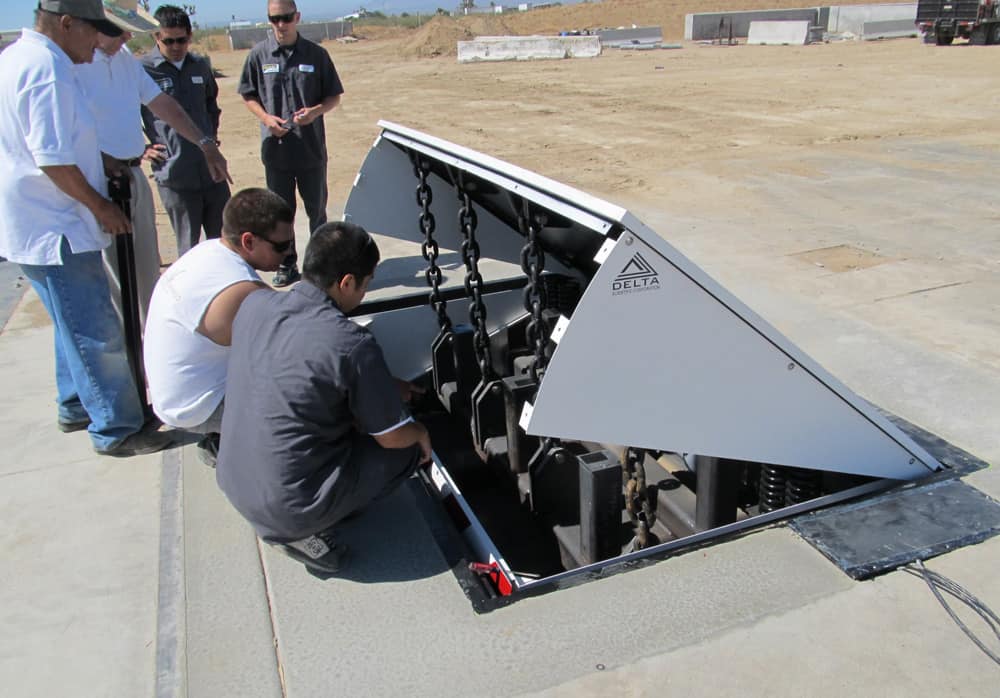 Delta Scientific technical team provides hands-on training and product support for a crash-rated vehicle barrier system, ensuring proper maintenance and operation as part of their commitment to customer service and security effectiveness.