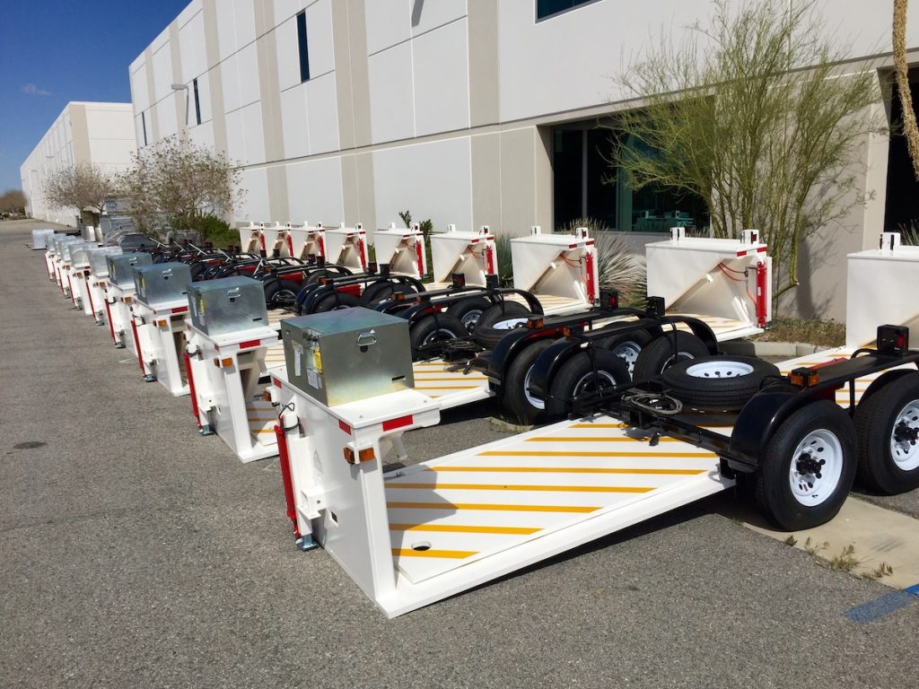 An array of Delta Scientific portable barrier units ready for deployment, lined up outside a facility, highlighting the company's proactive measures in response to heightened demand for quick-to-install security solutions