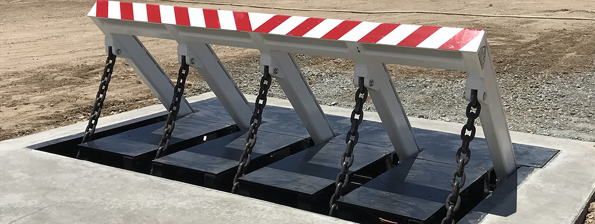 Close-up view of a Delta Scientific crash-certified vehicle barricade system, featuring a white and red striped arm raised at an angle, secured with chains, ready to ensure controlled vehicle access for high-security areas.