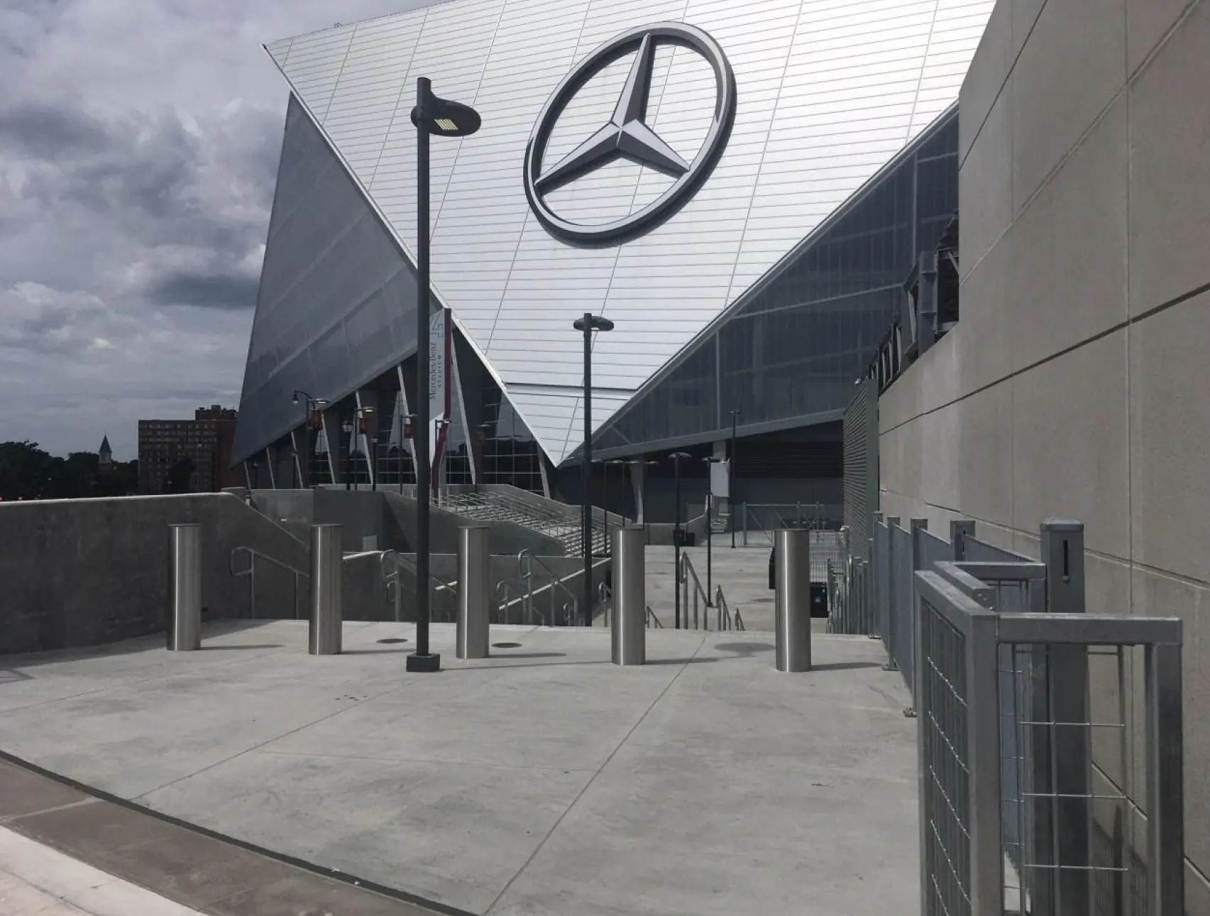 Delta Scientific bollards strategically placed at a stadium's entrance for heightened security, with the iconic Mercedes-Benz logo adorning the modern facade, showcasing commitment to protecting high-profile venues.